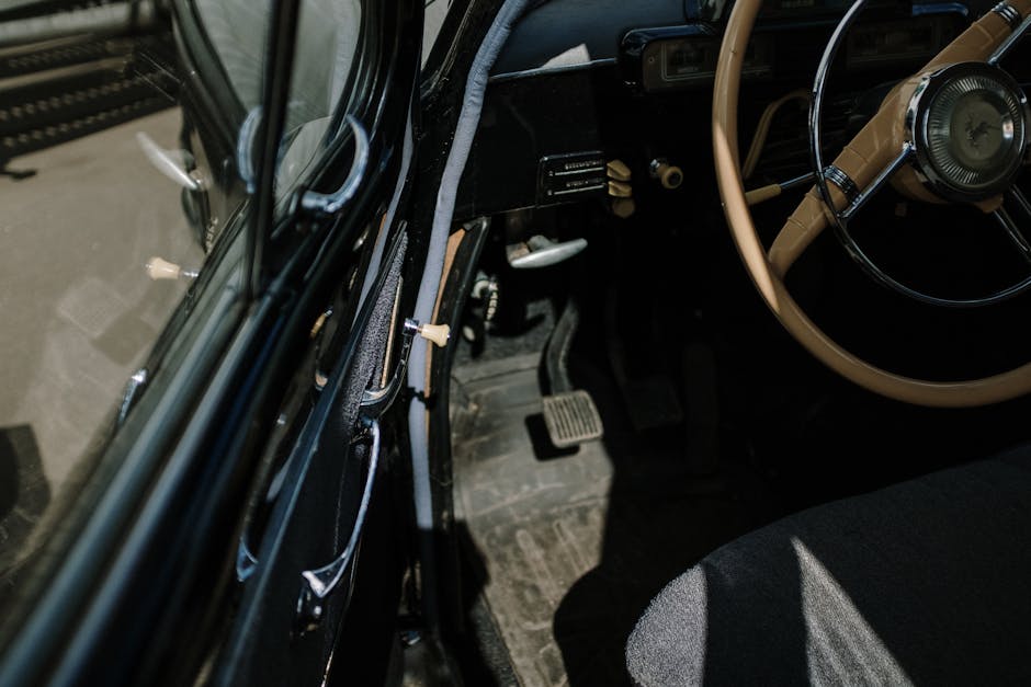 Close-up shot of a classic car interior showcasing steering wheel and dashboard.